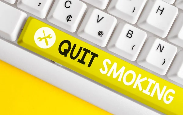 Conceptuele hand schrijven met Quit roken. Zakelijke foto tekst stopzetting of stoppen van het gebruik van tabaksverslaving wit PC-toetsenbord met notitie papier boven de witte achtergrond. — Stockfoto