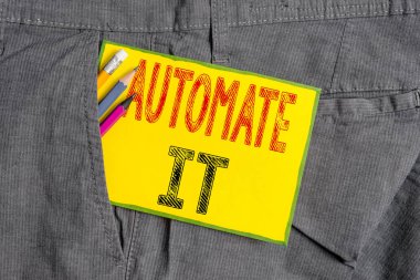 El yazısı metin yazma Otomatikleştir. Otomatik ekipman çalıştırılacak süreç veya tesis dönüştürmek anlamına gelir. Erkek iş pantolonunun cebine ekipman ve sarı not kağıdı yazma.