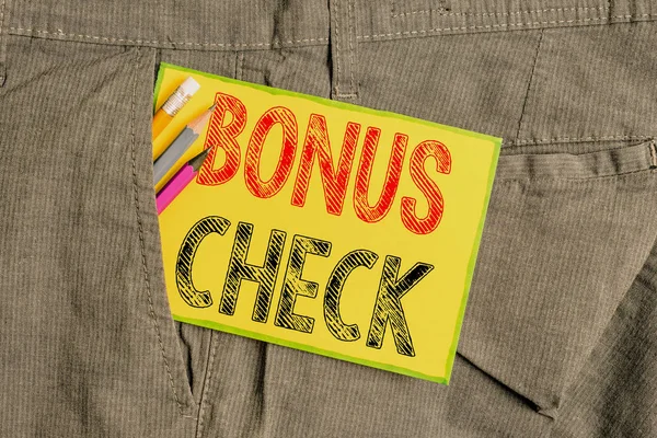 Handwriting text writing Bonus Check. Concept meaning something in addition to what is expected or strictly due Writing equipment and yellow note paper inside pocket of man work trousers.