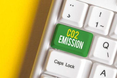 Co2 Emission yazılı el yazısı metin. Kavram anlamı zaman içinde atmosfere sera gazlarının serbest bırakılması Beyaz pc klavye beyaz arka plan anahtar kopyalama alanı üzerinde boş not kağıdı ile.