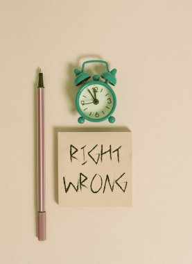 Doğru Yanlış'ı gösteren metin işareti. Kavramsal fotoğraf iki karar doğru ve kötü bir Metal vintage çalar saat uyandırma boş not defteri marker renkli arka plan yapmak arasında seçim.