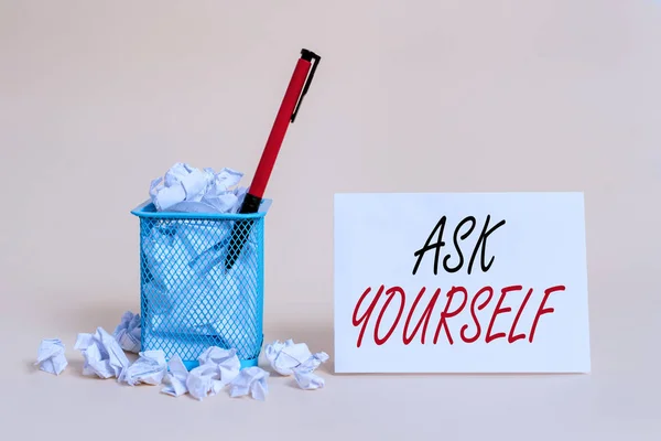 Text sign showing Ask Yourself. Conceptual photo Thinking the future Meaning and Purpose of Life Goals crumpled paper trash and stationary with note paper placed in the trash can.