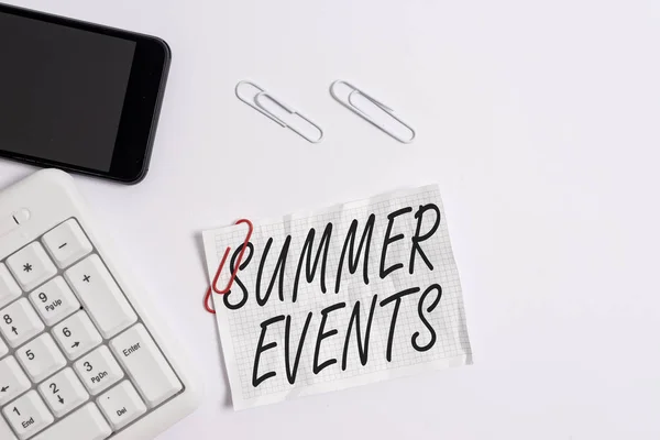 Textschild mit sommerlichen Ereignissen. konzeptionelle Foto-Feierlichkeiten, die im Sommer stattfinden, weiße PC-Tastatur mit leerem Notizpapier über weißem Hintergrund und Mobiltelefon. — Stockfoto