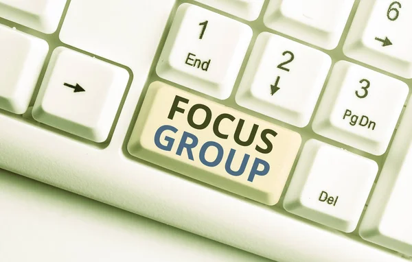 Text sign showing Focus Group. Conceptual photo showing assembled to participate in discussion about something White pc keyboard with empty note paper above white background key copy space. — Stock Photo, Image