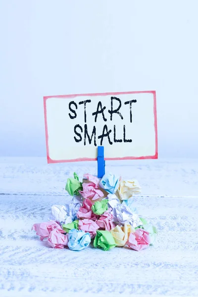 Writing note showing Start Small. Business photo showcasing Small medium enterprises start up Business entrepreneurship Reminder pile colored crumpled paper clothespin wooden space.