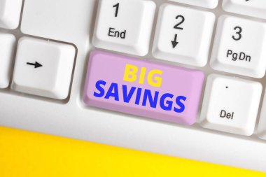 El yazısı metin Big Savings. Kavram anlamı gelir harcanmamış veya ertelenmiş tüketim beyaz arka plan tuşu kopyalama alanı üzerinde boş not kağıdı ile Beyaz pc klavye kenara para koyarak.