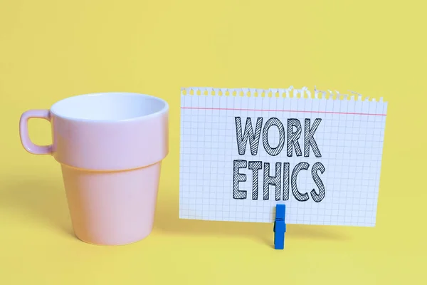 Writing note showing Work Ethics. Business photo showcasing A set of values centered on the importance of doing work Cup empty paper blue clothespin rectangle shaped reminder yellow office.