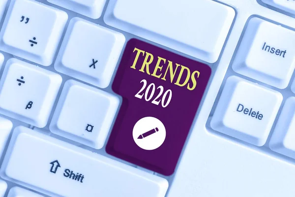 Handgeschreven tekst schrijven Trends 2020. Concept betekenis komende jaar heersende neiging wijd besproken online wit PC-toetsenbord met lege Opmerking papier boven witte achtergrond sleutel kopiëren ruimte. — Stockfoto