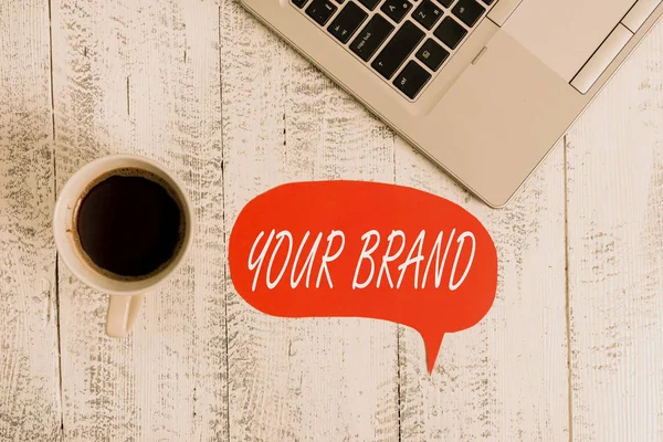 Word writing text Your Brand. Business concept for A name of any kind that is impacted to something as trademark Trendy metallic open laptop speech bubble vintage wooden table coffee cup.