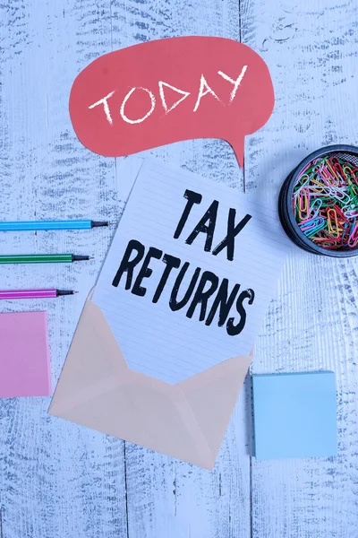 Word writing text Tax Returns. Business concept for Tax payer financial information Tax Liability and Payment report Envelop speech bubble paper sheet ballpoints notepads clips wooden back. — Stock Photo, Image