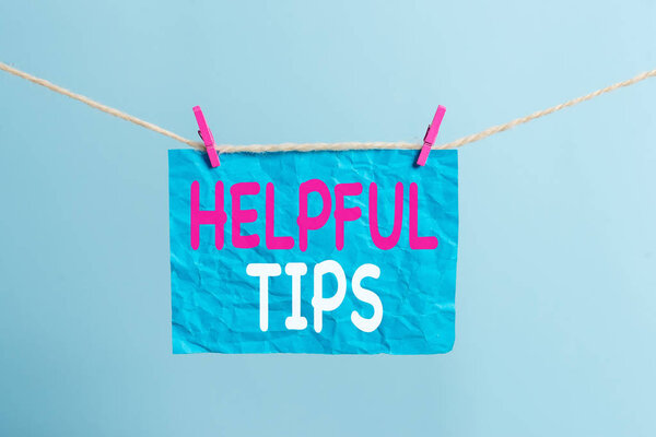 Writing note showing Helpful Tips. Business photo showcasing Useful secret Information Advice given to accomplish something Clothesline clothespin rectangle shaped paper reminder white wood desk.