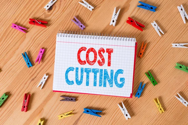 Conceptual hand writing showing Cost Cutting. Business photo text Measures implemented to reduced expenses and improved profit Colored crumpled papers wooden floor background clothespin.