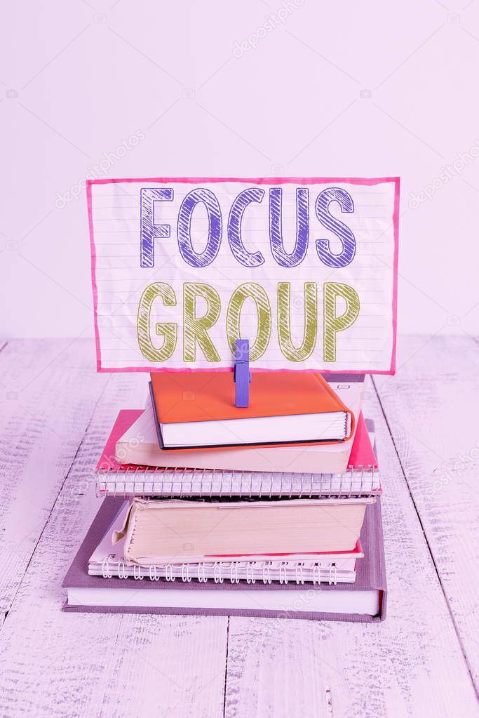 Word writing text Focus Group. Business concept for showing assembled to participate in discussion about something pile stacked books notebook pin clothespin colored reminder white wooden.