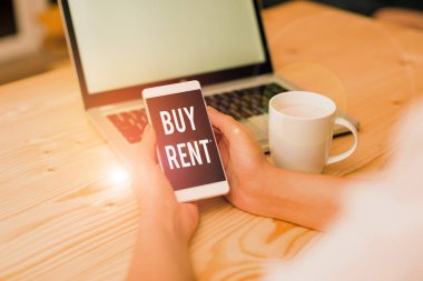 El yazısı metin yazma Buy Rent. Kavram bir şey satın alma veya kullanım için ödeme kadın dizüstü bilgisayar akıllı telefon kupa ofis malzemeleri teknolojik cihazlar arasında seçim anlamı.