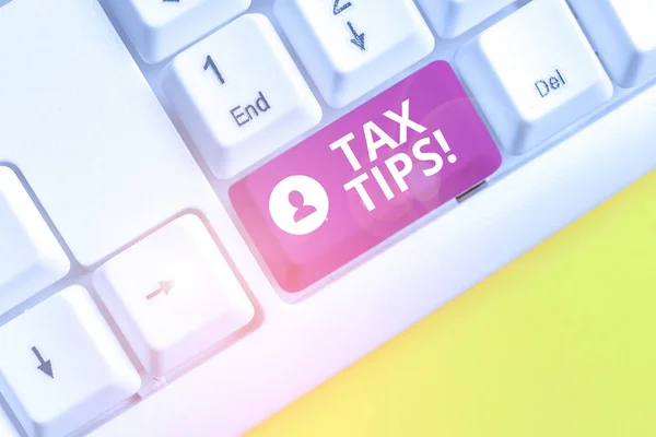 Writing note showing Tax Tips. Business photo showcasing compulsory contribution to state revenue levied by government White pc keyboard with note paper above the white background.