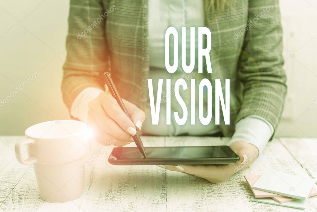 Writing note showing Our Vision. Business photo showcasing plan for next five to ten years about company goals to be made Business woman sitting with mobile phone and cup of coffee on the table.