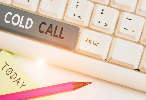 Writing note showing Cold Call. Business photo showcasing Unsolicited call made by someone trying to sell goods or services White pc keyboard with note paper above the white background.