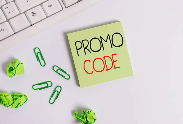Handwriting text Promo Code. Concept meaning digital numbers that give you good discount on certain product Square empty green note paper with pencil on the white background and pc keyboard.