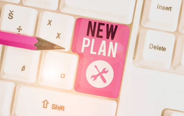 Textschild mit neuem Plan. konzeptioneller Fototermin eines detaillierten Vorschlags, etwas zu tun oder zu erreichen, weiße PC-Tastatur mit leerem Notizpapier über weißem Hintergrund Schlüsselkopierraum. — Stockfoto