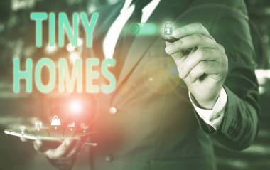Tiny Homes'u gösteren bir metin işareti. Kavramsal fotoğraf evleri sadece bir oda veya iki ve küçük giriş Ucuz Erkek insan giyim resmi iş elbisesi akıllı cihaz kullanarak sunum sunan içerir.