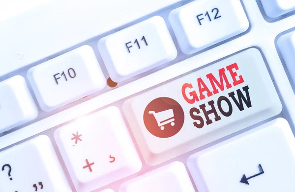 Text sign showing Game Show. Conceptual photo Program in television or radio with players that win prizes White pc keyboard with empty note paper above white background key copy space.