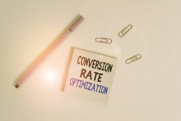 Writing note showing Conversion Rate Optimization. Business photo showcasing system for increasing percentage of visitors Colored sticky note clips binders gathered pen trendy cool background.