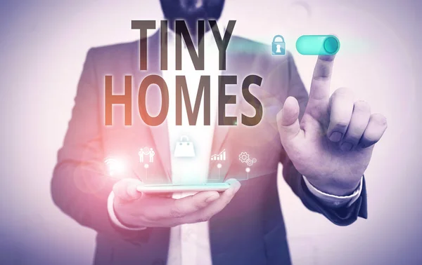 Word writing text Tiny Homes. Business concept for houses contain one room only or two and small entrance Cheap Male human wear formal work suit presenting presentation using smart device.