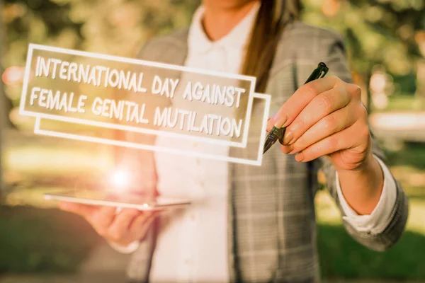 Assinatura de texto mostrando Dia Internacional Contra. Foto conceitual Dia Internacional Contra a Mutilação Genital Feminina Fundo ao ar livre com mulher de negócios segurando lap top e caneta . — Fotografia de Stock