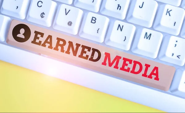 Text sign showing Earned Media. Conceptual photo publicity gained through promotional efforts other than paid White pc keyboard with empty note paper above white background key copy space.