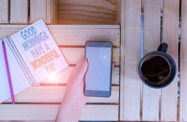 Kelime yazma metin Günaydın Ve Harika Bir Gün var. Gün başında birini selamlama için iş konsepti kadın bilgisayar akıllı telefon içki kupa ofis malzemeleri teknolojik cihazlar.