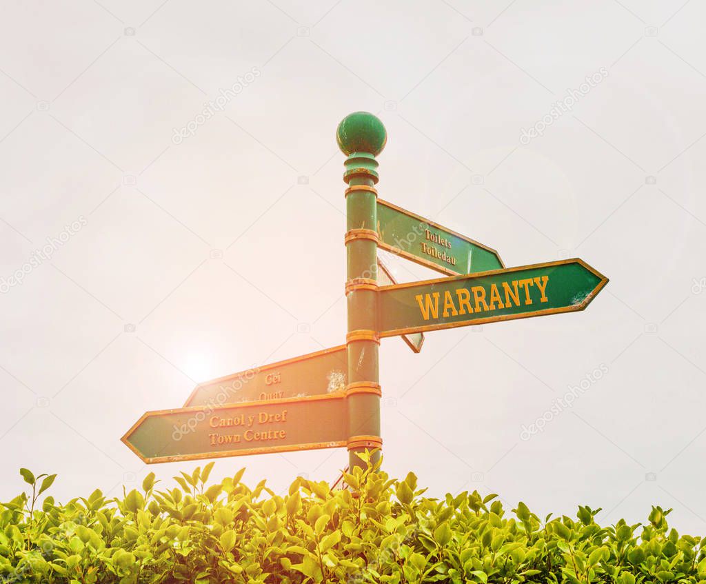 Handwriting text Warranty. Concept meaning Free service of repair and maintenance of the product sold Green road sign on the crossroads with blue sky and green grass in the background.