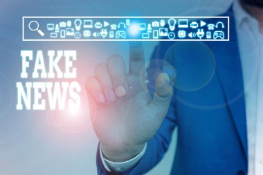 Sahte haberleri gösteren bir not yazıyorum. Bunun medya tarafından doğru olmadığını gösteren bilgi veren iş fotoğrafı gösterimi. Erkek, sunum akıllı aygıtı sunan resmi iş elbisesi giyer..