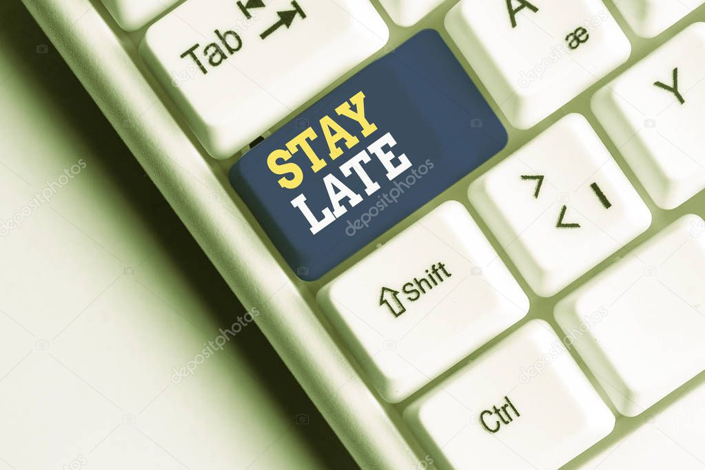 Conceptual hand writing showing Stay Late. Business photo showcasing A routine in which a demonstrating goes to somewhere out of time White pc keyboard with note paper above the white background.