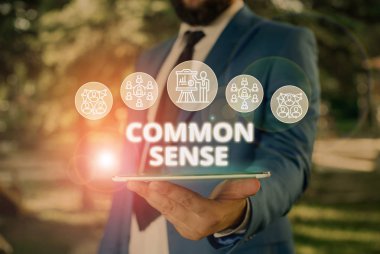 Kelime yazma metni Common Sense. Pratik konularda sağduyu ve ses yargısı için iş konsepti Erkek insan giyim resmi iş elbisesi akıllı cihaz kullanarak sunum sunan.
