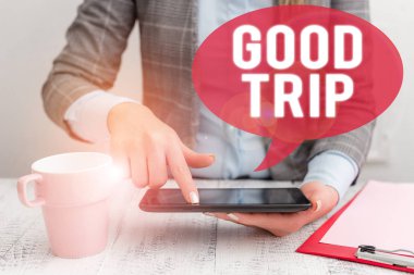 Good Trip'i gösteren bir metin işareti. Kavramsal fotoğraf Bir yolculuk veya yolculuk, tekne, tren, otobüs, ya da herhangi bir araç Iş kadın cep telefonu ve masada kahve fincan ile oturan tarafından işletilen.