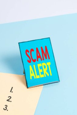 Scam Alert'i gösteren not yazma. İş fotoğrafı vitrin düzeni veya dolandırıcılık hakkında uyarı herhangi bir olağandışı haber.