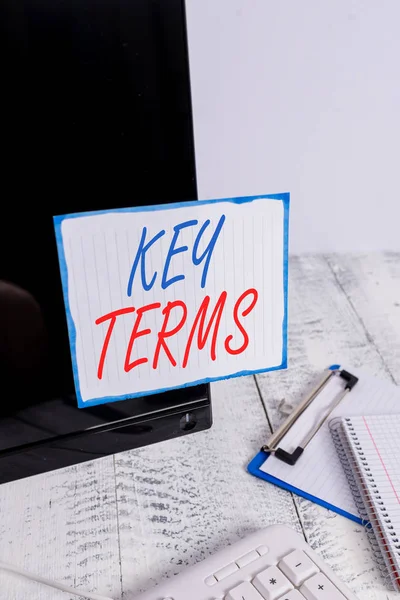 Writing note showing Key Terms. Business photo showcasing Words that can help a demonstrating in searching information they need Note paper taped to black computer screen near keyboard and stationary.