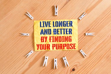 Amacınızı Bularak Daha Uzun Ve Daha İyi Yiyerek Canlı'yı gösteren not yazmak. İş fotoğraf vitrin bir hedef seti misyonu renkli clothespin kağıtları boş hatırlatma ahşap zemin arka plan ofis arayın.