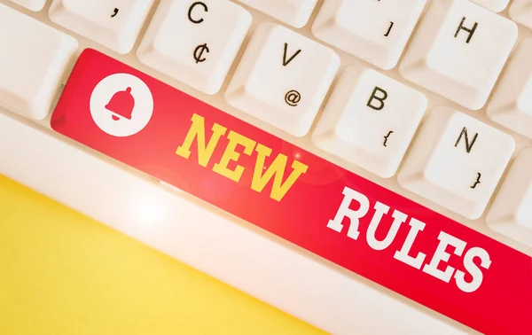 Text sign showing New Rules. Conceptual photo A state of changing an iplemented policy for better upgrade White pc keyboard with empty note paper above white background key copy space.