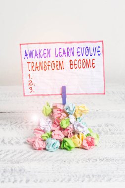Awaken Learn Evolve Transform Become'u gösteren kavramsal el yazısı. İş fotoğraf metin İlham Motivasyon Hatırlatma artırın kazık renkli buruşuk kağıt clothespin ahşap alan.