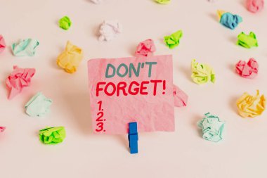 Don T Forget'ı gösteren kavramsal el yazısı. Önemli gerçeği veya detay Hakkında birisi hatırlatmak için kullanılan iş fotoğraf metin Renkli buruşturulmuş kağıt boş hatırlatma beyaz zemin clothespin.