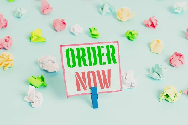 Word writing text Order Now. Business concept for service restaurants or stores provide to get what you need home Colored crumpled papers empty reminder blue floor background clothespin.