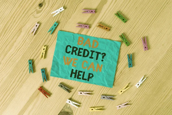 Word writing text Bad Credit Question We Can Help. Business concept for Borrower with high risk Debts Financial Colored clothespin papers empty reminder wooden floor background office.