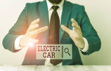 Electric Car 'ın el yazısı. Kavram, bir veya daha fazla elektrik motoru tarafından itilen bir otomobil anlamına gelir. İnsan önünde kopyalama alanı olan boş bir kağıt tutar..