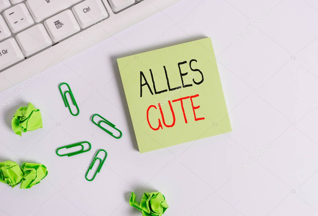 Handwriting text Alles Gute. Concept meaning geranalysis translation all the best for birthday or any occasion Square empty green note paper with pencil on the white background and pc keyboard.
