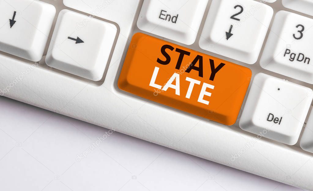 Writing note showing Stay Late. Business photo showcasing A routine in which a demonstrating goes to somewhere out of time White pc keyboard with note paper above the white background.