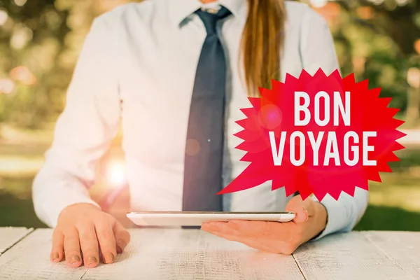 Szövegírás Bon Voyage. Üzleti koncepció a használt kifejezésre jókívánságok valakinek az utazásról Női üzletember asztalnál ülve és mobiltelefont tartva. — Stock Fotó