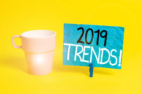 Handwriting text 2019 Trends. Concept meaning general direction in which something is developing or changing Cup empty paper blue clothespin rectangle shaped reminder yellow office.