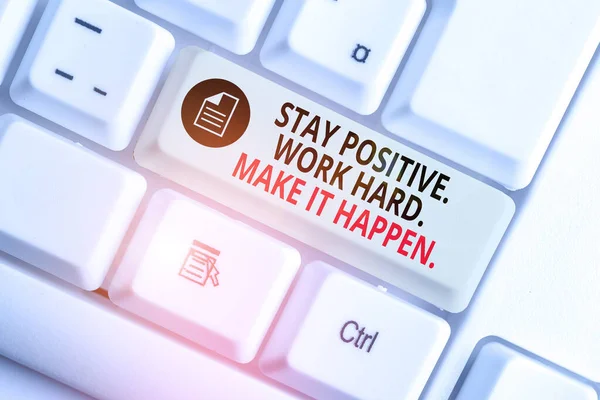 Написання тексту "Залишайся позитивною працею, щоб це сталося". Концепт означає вплив мотивації Attitude White pc клавіатура з порожньою нотаткою над білим фоновим простором копіювання ключа. — стокове фото