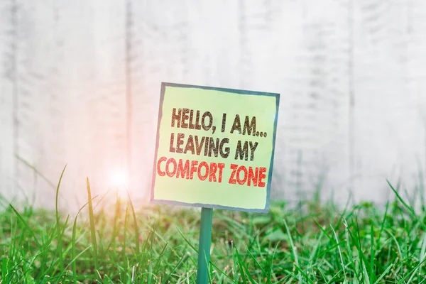 Conceptual hand writing showing Hello I Am Leaving My Comfort Zone. Business photo showcasing Making big changes Evolution Growth Plain paper attached to stick and placed in the grassy land. — Stockfoto